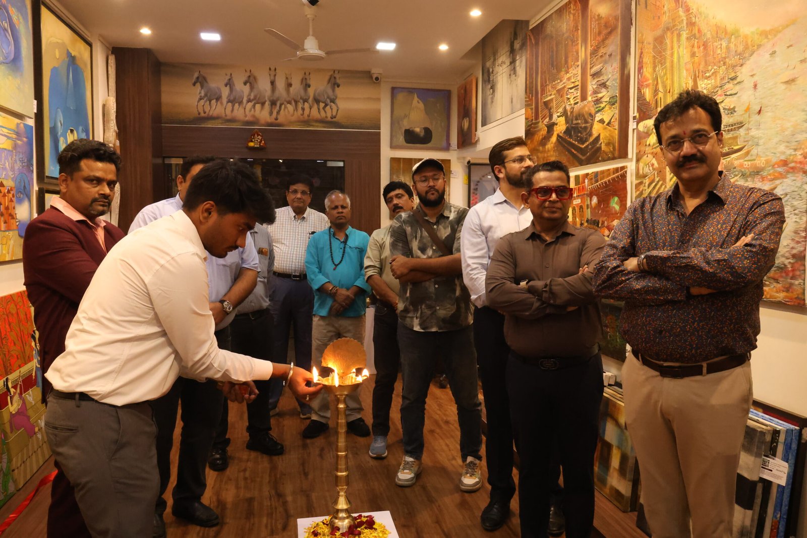 Traditional lamp lighting ceremony marking the inauguration of an art exhibition in Mumbai at JMD Art Gallery.